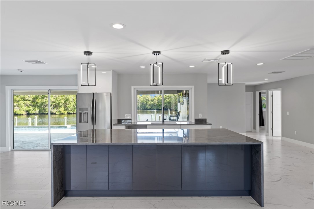 432 Seaworthy Road North Fort Myers, FL 33903 - Photo 10 of 28 a kitchen with kitchen island large windows and refrigerator