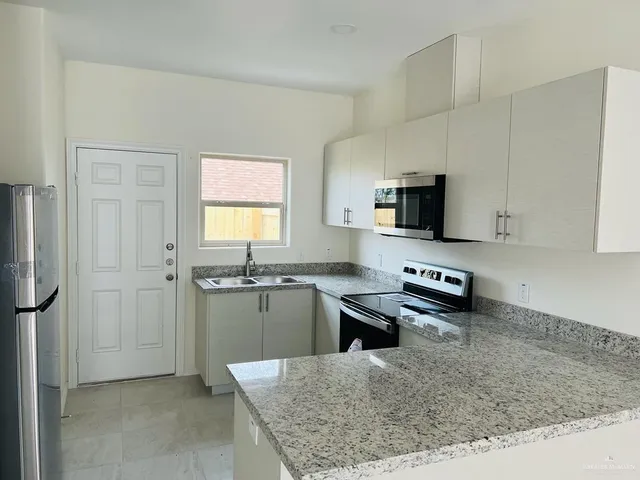 a kitchen with a refrigerator and a stove top oven