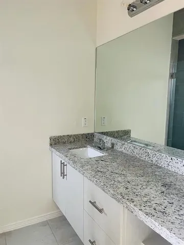 a bathroom with a granite countertop sink and vanity