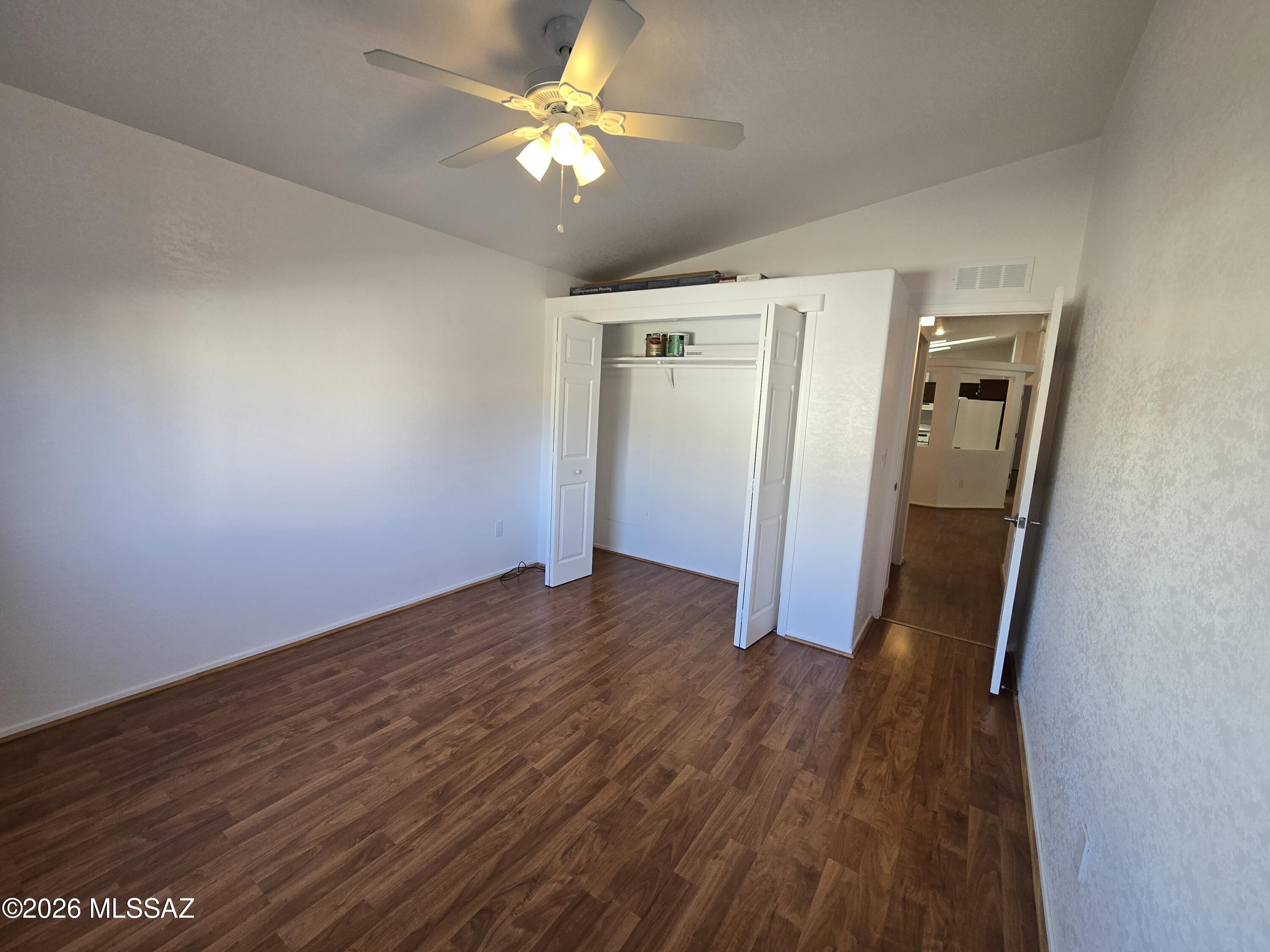 8401 South Kolb Road, Unit 61 Tucson, AZ 85756 - Photo 9 of 23 an empty room with wooden floor and a ceiling fan