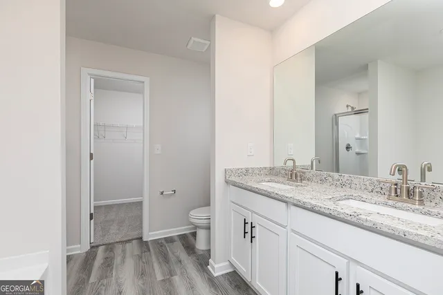 a bathroom with a granite countertop sink a mirror and a toilet