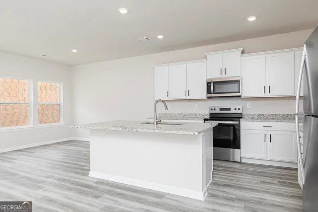 a kitchen with stainless steel appliances granite countertop a sink a stove and a refrigerator