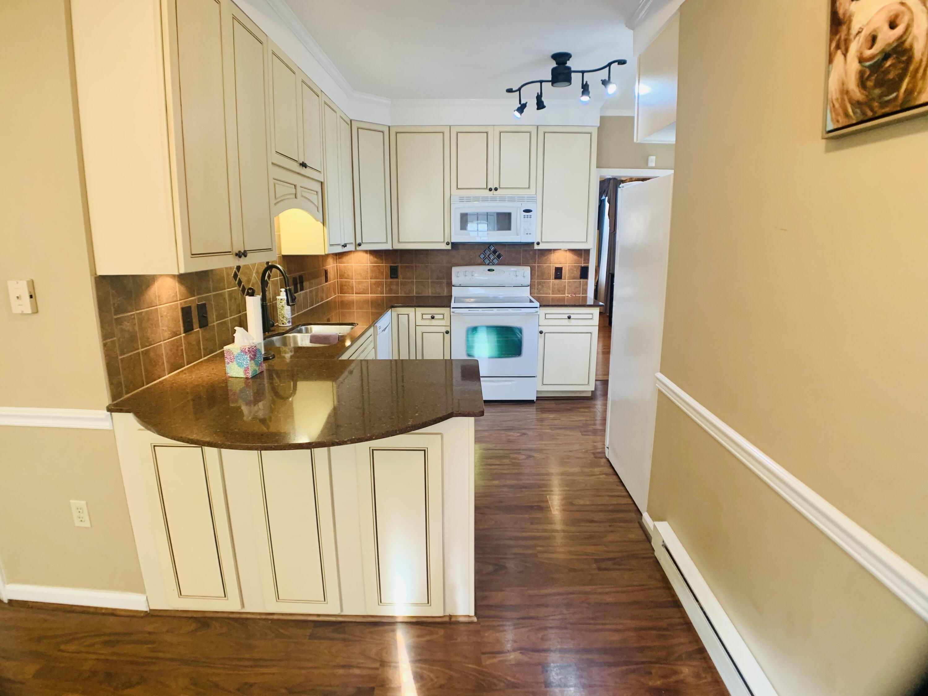 709 McCormick Boulevard Clifton Forge, VA 24422 - Photo 25 of 74 a kitchen with stainless steel appliances a refrigerator a sink a stove and white cabinets with wooden floor