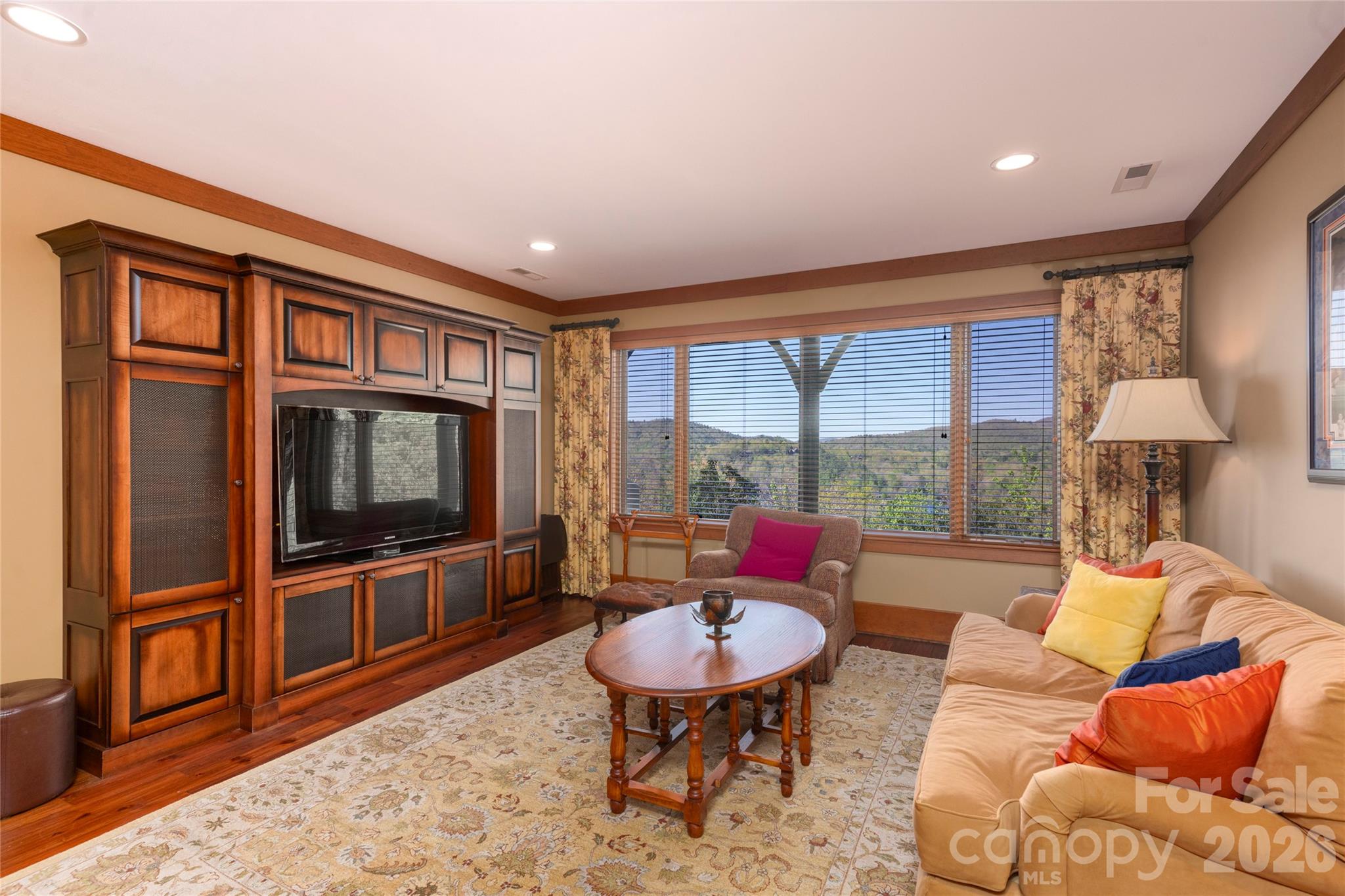 601 Hawk Mountain Road Lake Toxaway, NC 28747 - Photo 32 of 48 a living room with furniture a flat screen tv and a floor to ceiling window