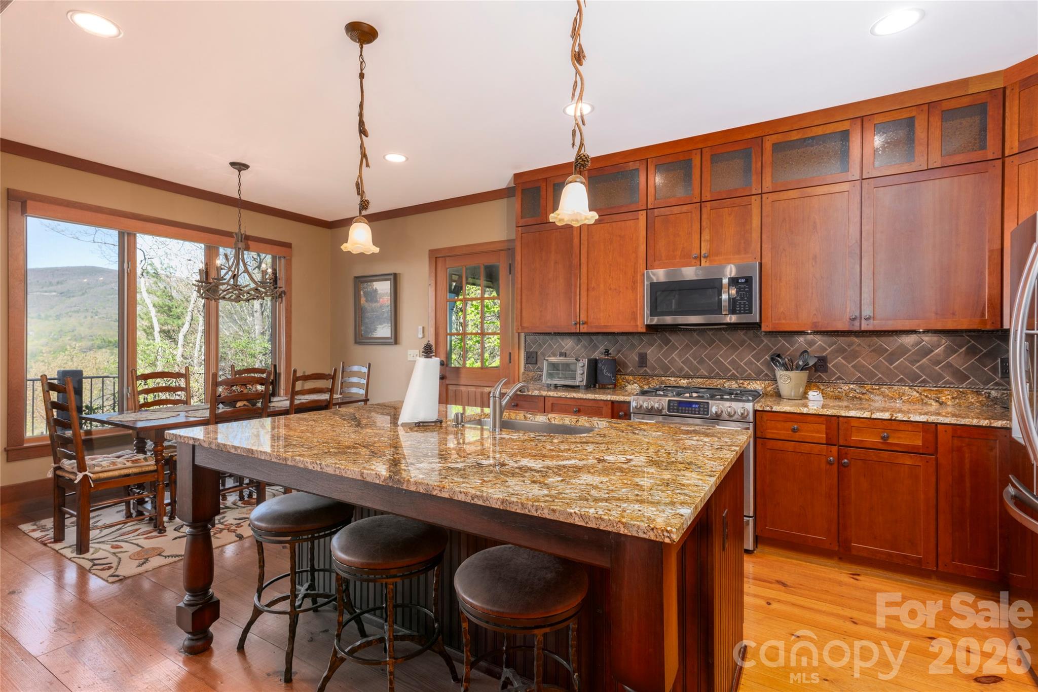 601 Hawk Mountain Road Lake Toxaway, NC 28747 - Photo 10 of 48 a kitchen with stainless steel appliances granite countertop a stove a sink dishwasher and a wooden cabinets with large windows
