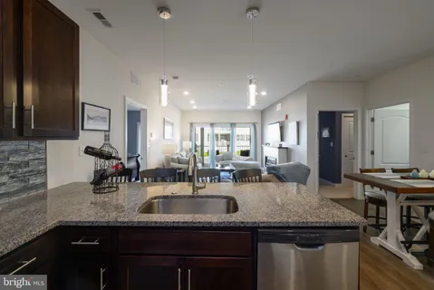 a kitchen with stainless steel appliances granite countertop a sink refrigerator and cabinets