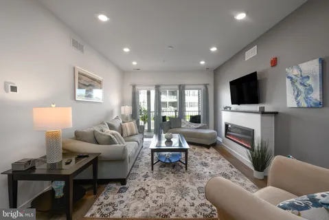 a living room with furniture a flat screen tv and a fireplace