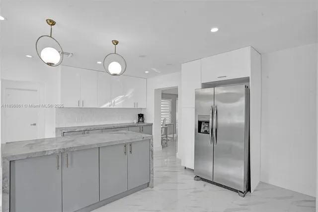 a kitchen with stainless steel appliances a table chairs and a chandelier