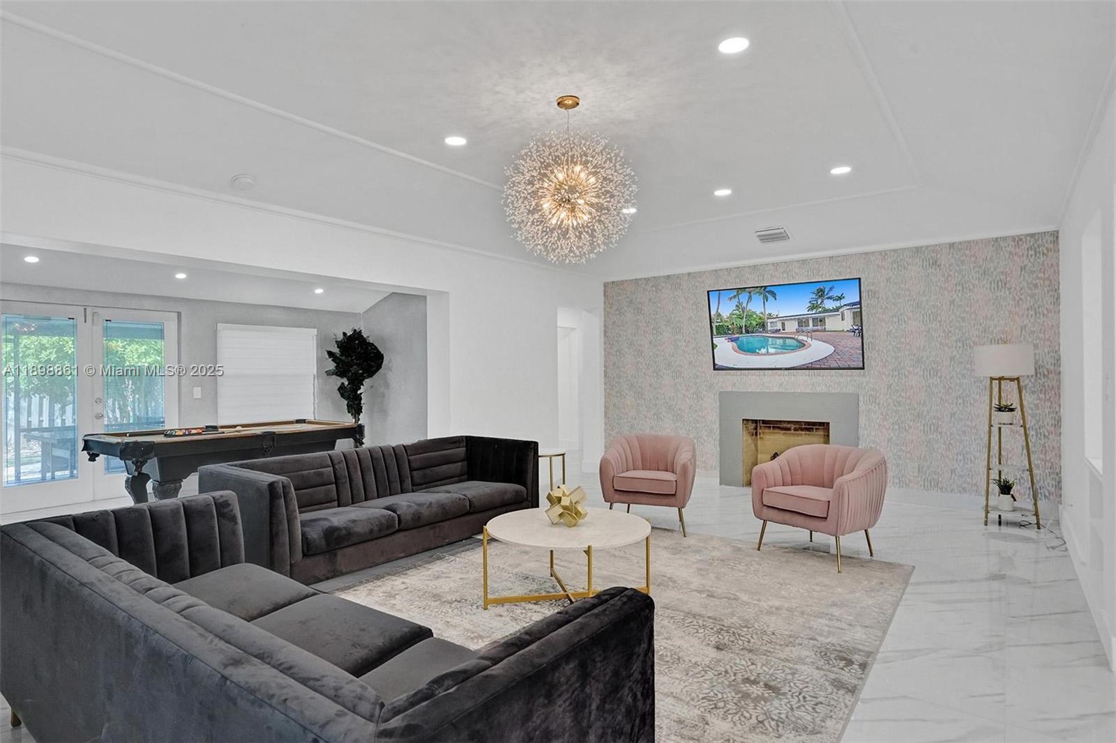 725 Harrison Street Hollywood, FL 33019 - Photo 16 of 91 a living room with furniture and a chandelier