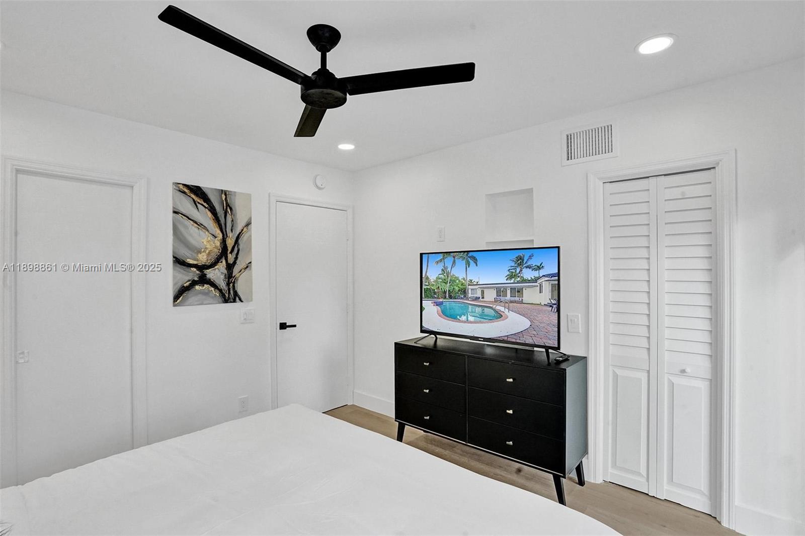 725 Harrison Street Hollywood, FL 33019 - Photo 47 of 91 a bedroom with a bed and a chandelier