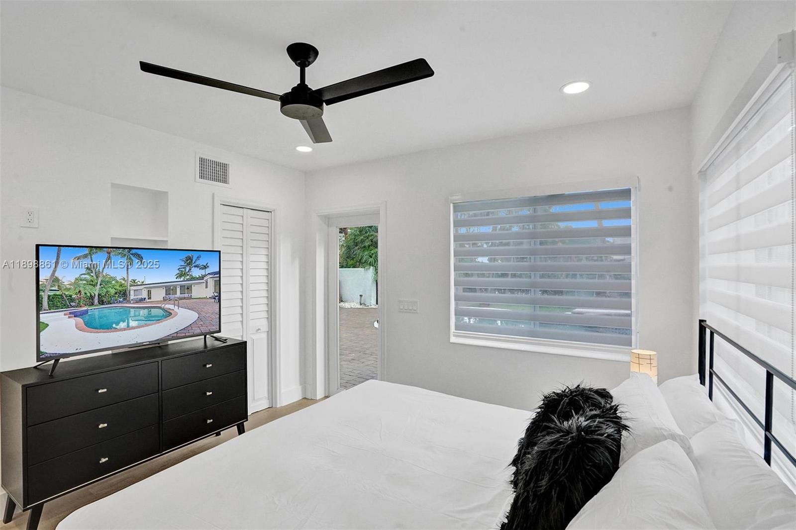 725 Harrison Street Hollywood, FL 33019 - Photo 48 of 91 a bedroom with a bed and a flat tv screen on dresser