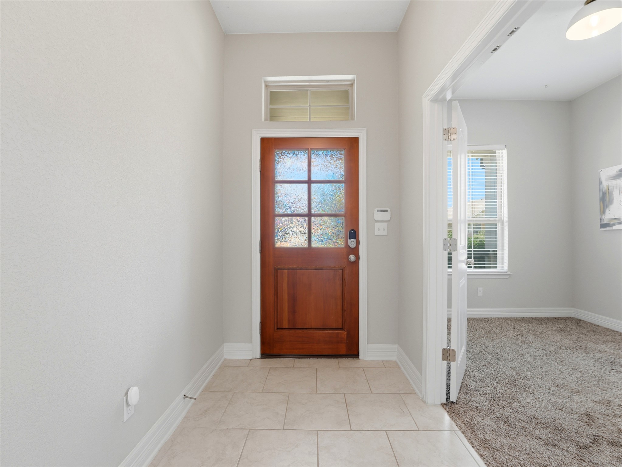2132 Ringstaff Road Leander, TX 78641 - Photo 11 of 39 A well-lit entry hall features a warm wood door with frosted glass and a transom window above.