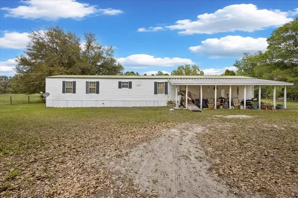 a view of house with a backyard