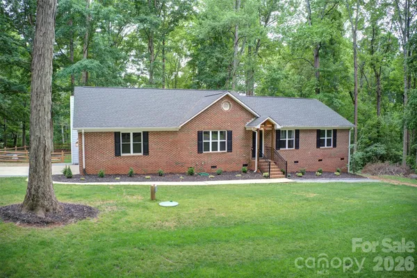 a front view of a house with a yard and trees
