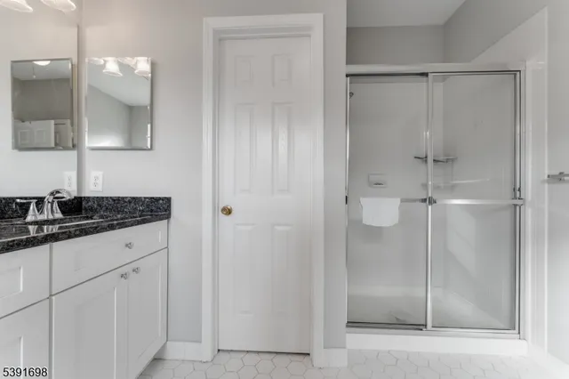 a bathroom with a granite countertop sink mirror and shower
