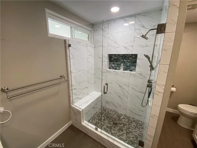 a bathroom with a granite countertop shower and a toilet