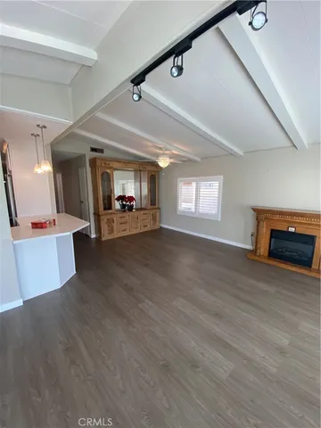 a view of a hallway with wooden floor and fireplace