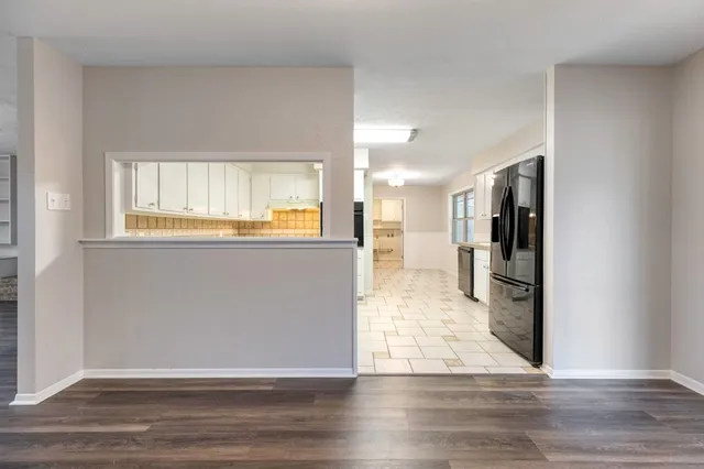 a view of a big room with wooden floor and a window