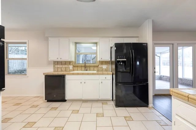 a kitchen with a refrigerator and a stove top oven