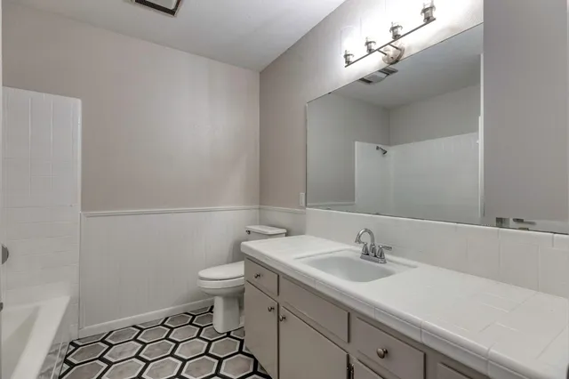 a bathroom with a sink a toilet and vanity