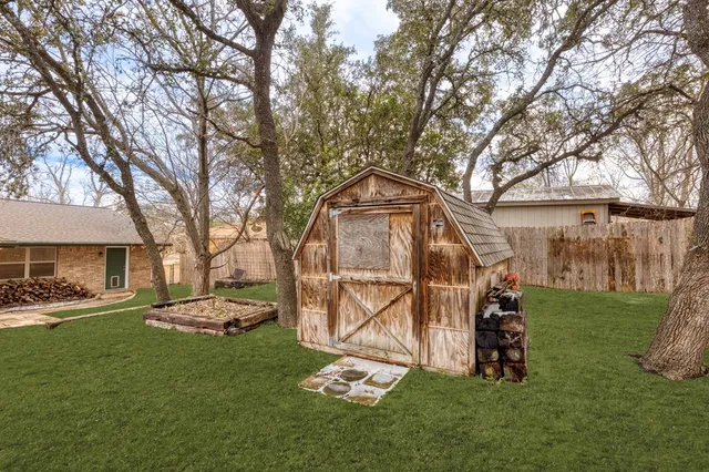 a view of a field with large trees