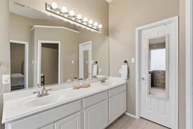 a spacious en suite bathroom with double sink and a mirror