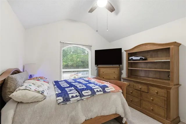 a bedroom with a bed and flat tv screen