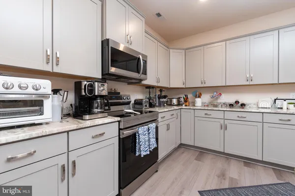 a kitchen with granite countertop white cabinets and white appliances