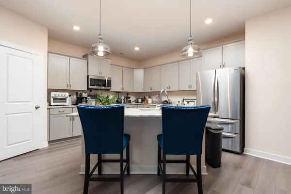 a kitchen with kitchen island wooden cabinets and stainless steel appliances