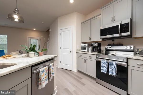 a kitchen with stainless steel appliances granite countertop a sink a stove and a microwave