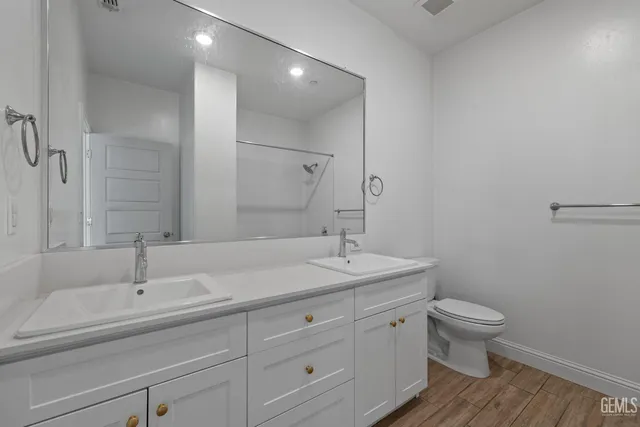 a bathroom with a sink a toilet and a mirror