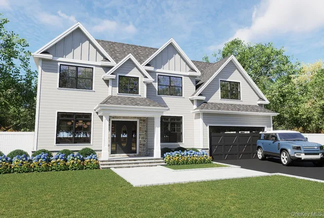 a front view of a house with a garden and yard