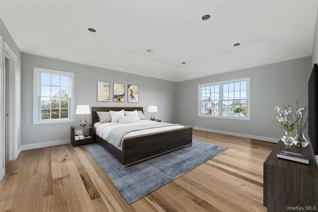 a large kitchen with granite countertop a refrigerator a stove a sink dishwasher and white cabinets with wooden floor