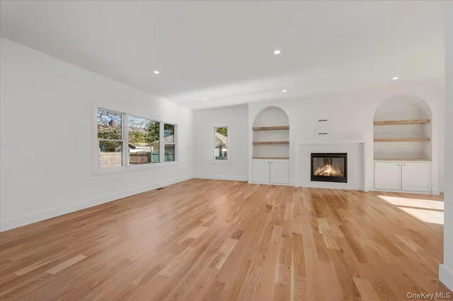 a view of empty room with wooden floor and fireplace