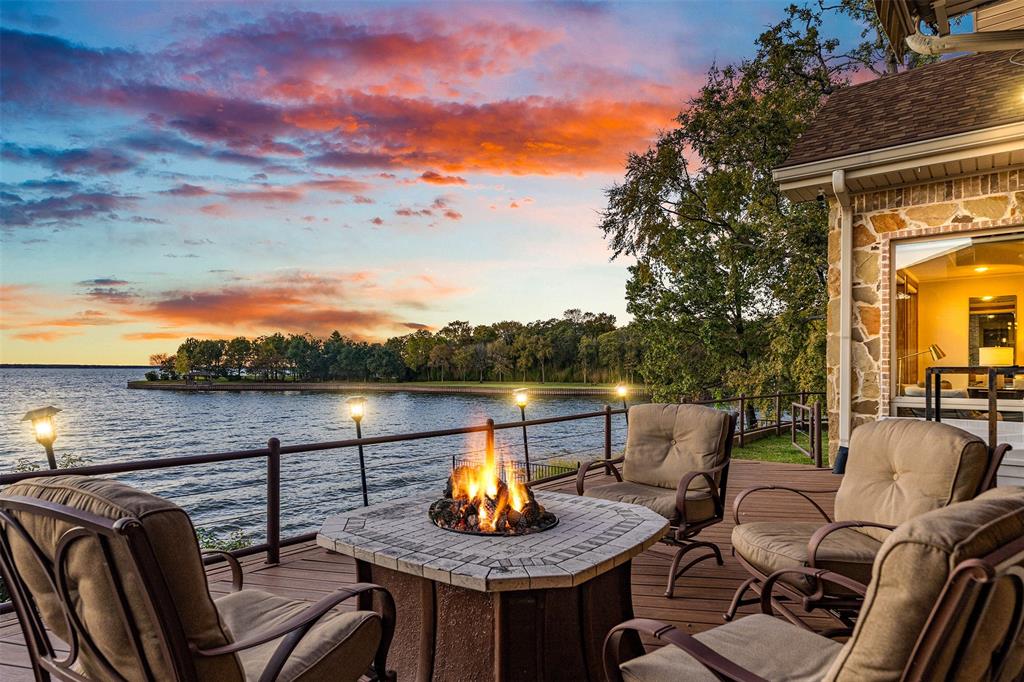 Deck at dusk featuring a water view and an outdoor fire pit