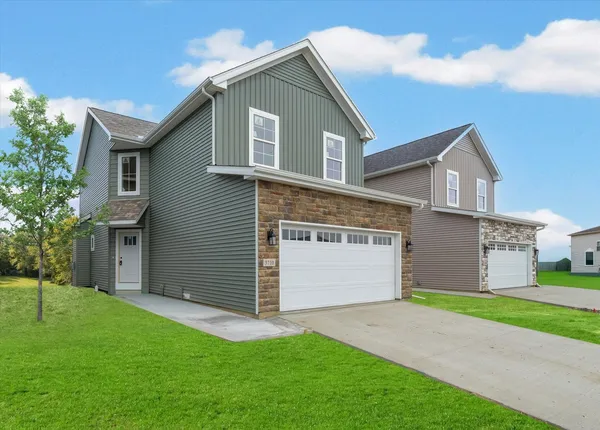 a front view of house with yard and garage