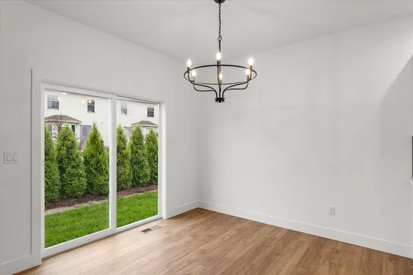 a view of a room with a large window and wooden floor