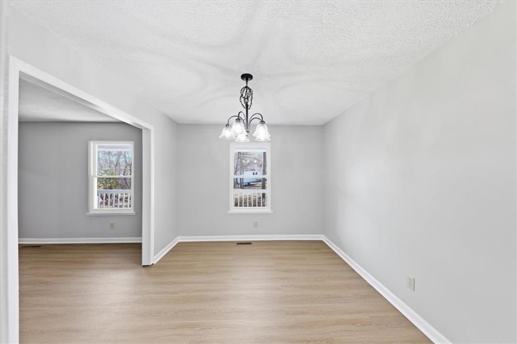 8976 Ochil Lane Winston, GA 30187 - Photo 11 of 53 an empty room with wooden floor and windows