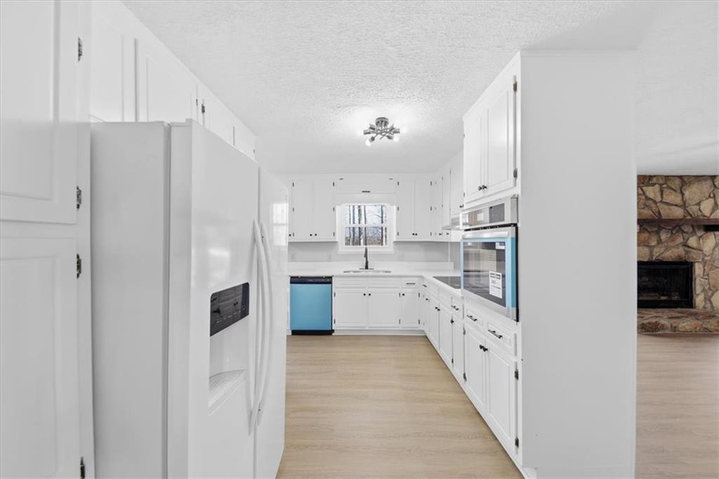 8976 Ochil Lane Winston, GA 30187 - Photo 12 of 53 a kitchen with white cabinets and refrigerator