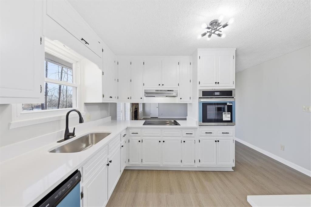 8976 Ochil Lane Winston, GA 30187 - Photo 16 of 53 a kitchen with stainless steel appliances a sink a stove a microwave a sink a refrigerator and cabinets