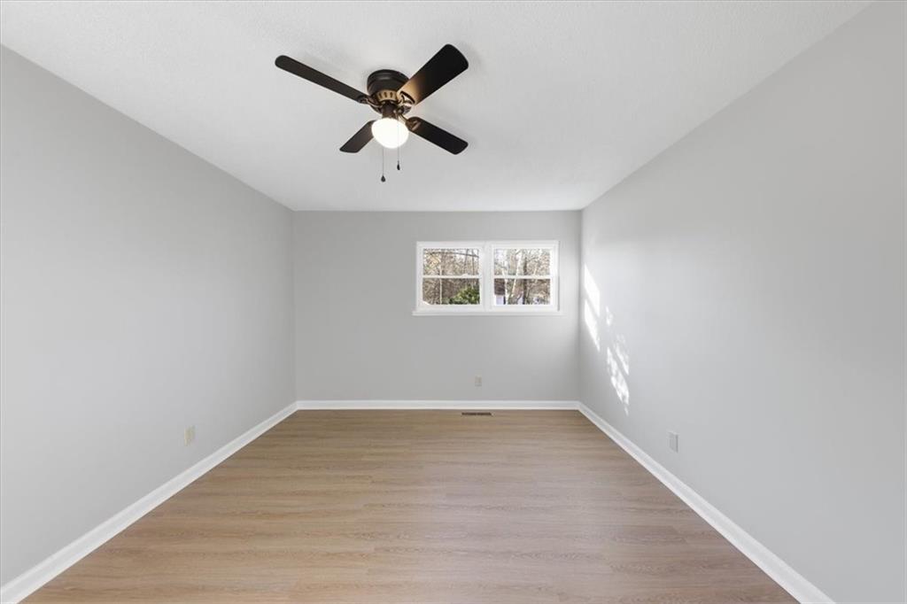 8976 Ochil Lane Winston, GA 30187 - Photo 32 of 53 a view of empty room with wooden floor and fan