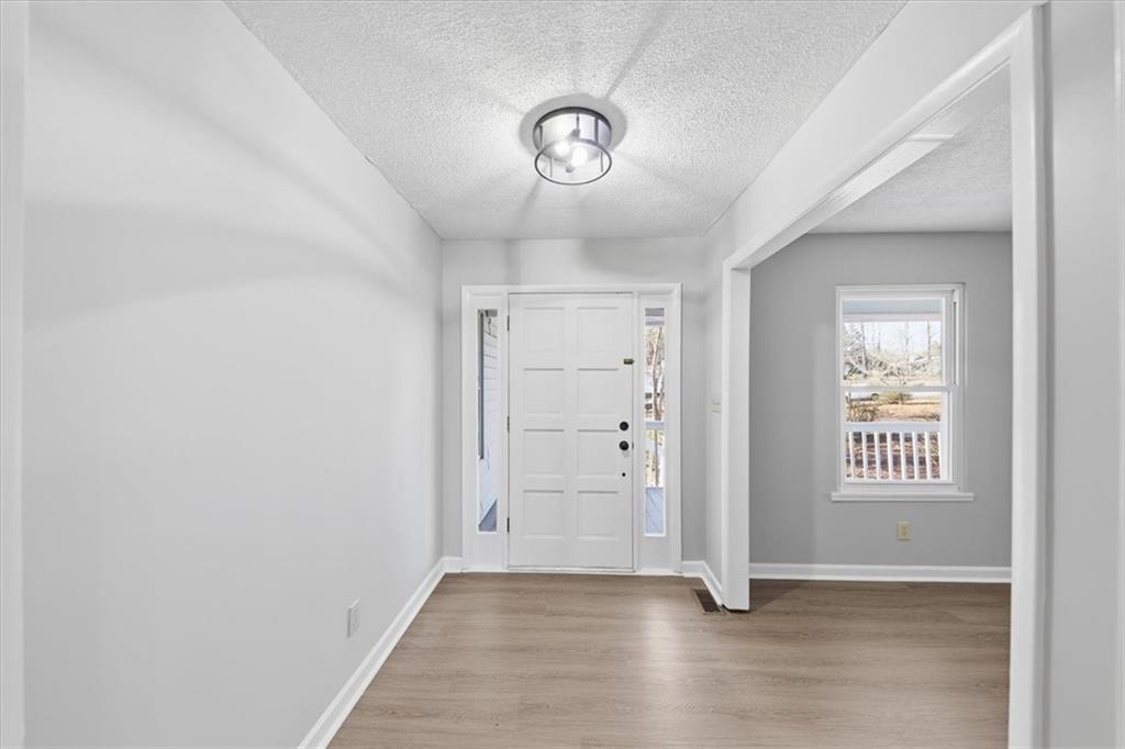 8976 Ochil Lane Winston, GA 30187 - Photo 6 of 53 an empty room with wooden floor and a window