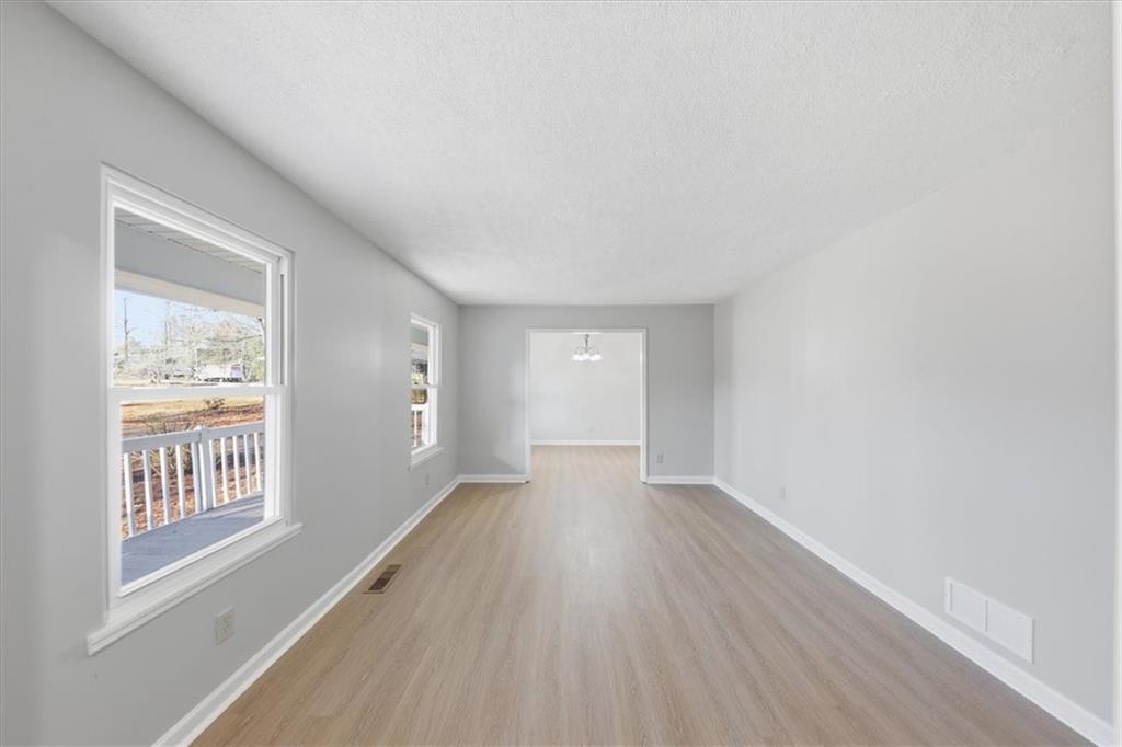 8976 Ochil Lane Winston, GA 30187 - Photo 7 of 53 a view of an empty room with wooden floor and a window