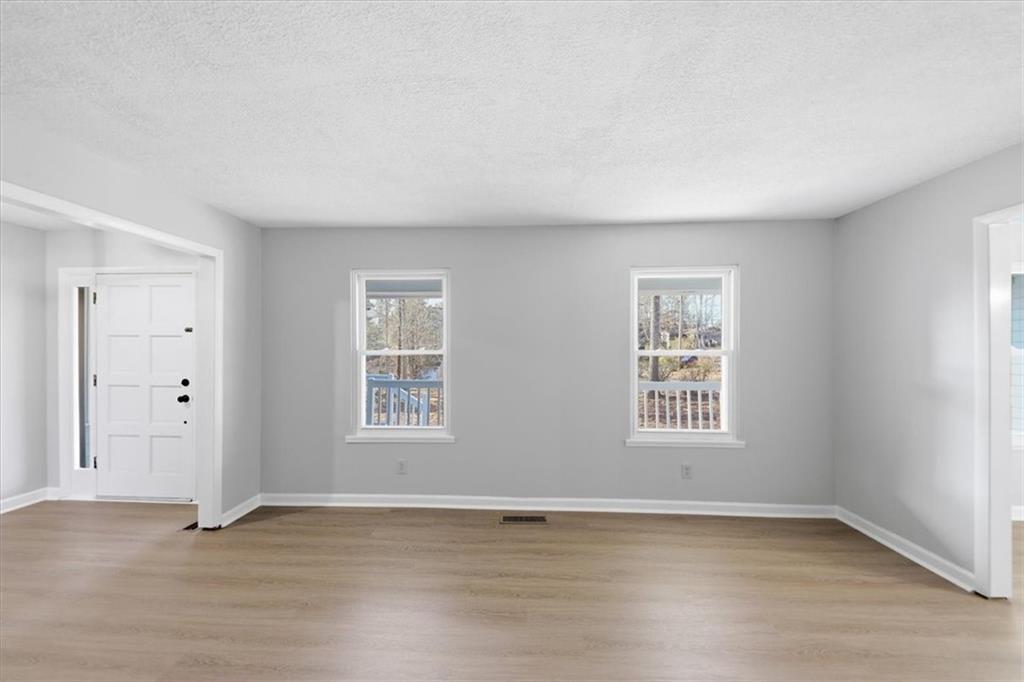 8976 Ochil Lane Winston, GA 30187 - Photo 8 of 53 an empty room with wooden floor and windows