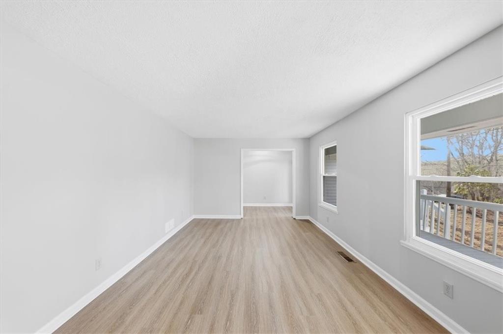 8976 Ochil Lane Winston, GA 30187 - Photo 9 of 53 an empty room with wooden floor and windows