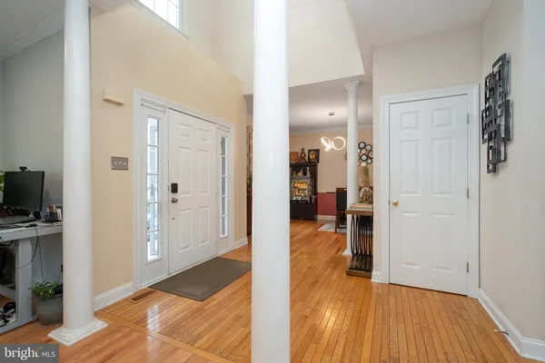a view of a hallway with wooden floor and a bathroom