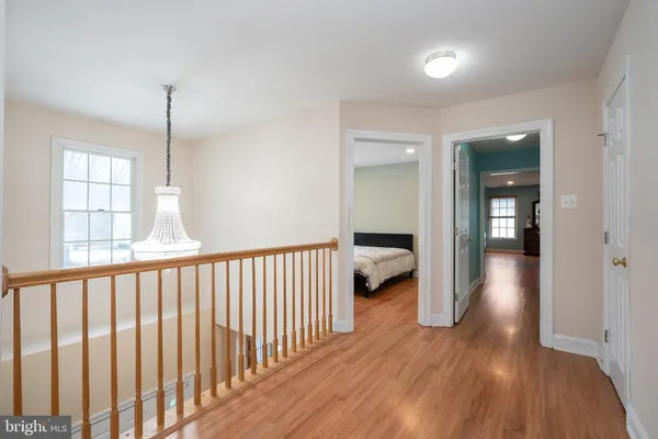 a bedroom with a large bed and wooden floor