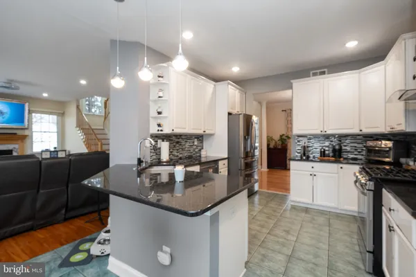 a kitchen with stainless steel appliances granite countertop a sink a stove and a refrigerator