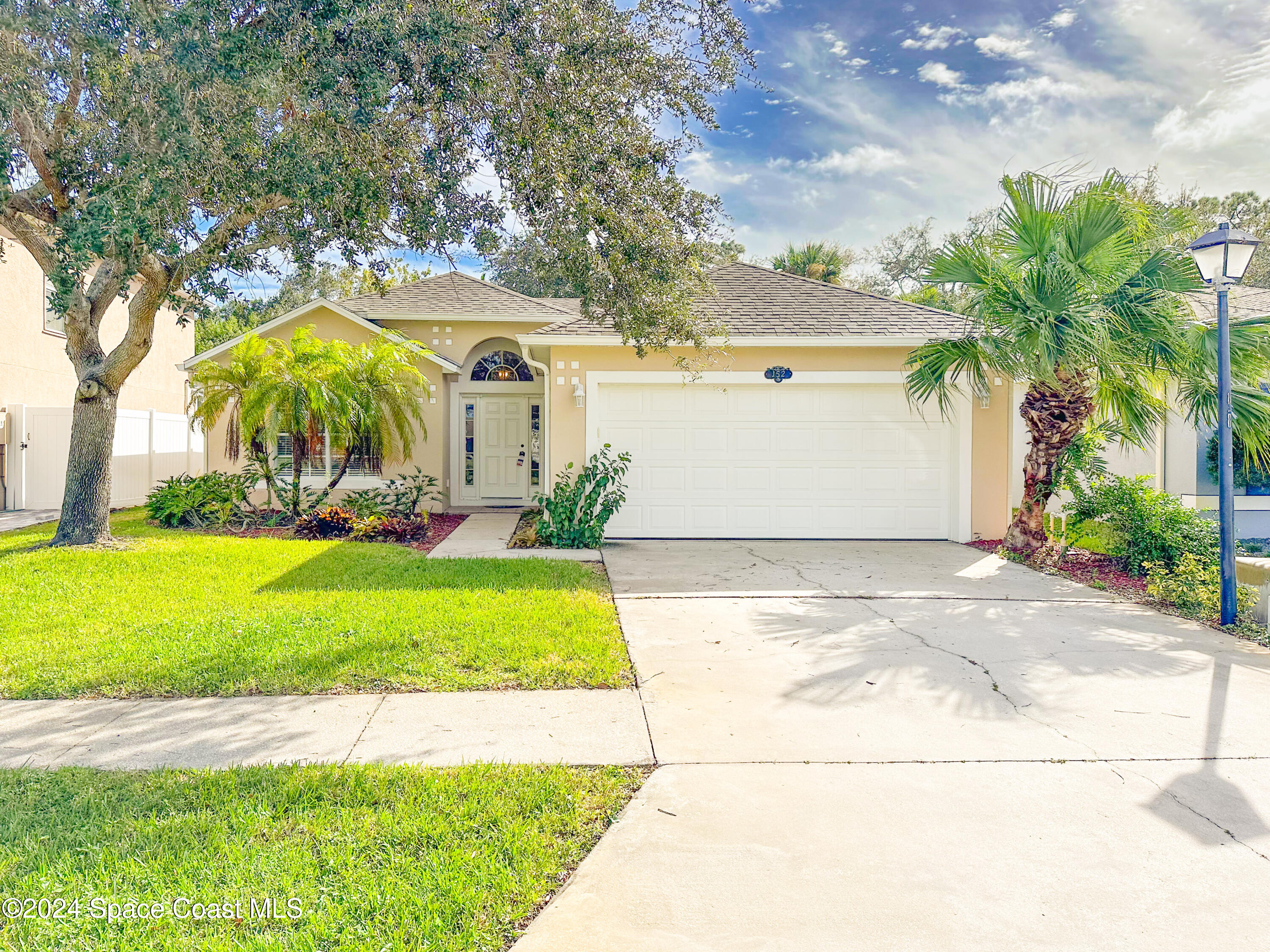 152 Morgan Circle Sebastian, FL 32958 - Photo 2 of 64 a view of a yard with an umbrella and palm trees