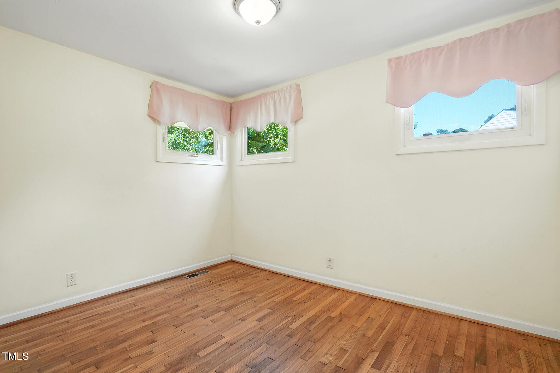 912 Dixie Trail Raleigh, NC 27607 - Photo 19 of 27 an empty room with wooden floor and window